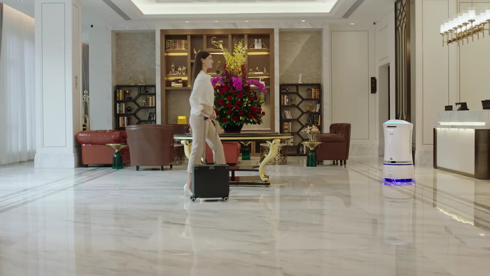 Vestíbulo de hotel con recepción, asientos y piso de mármol.